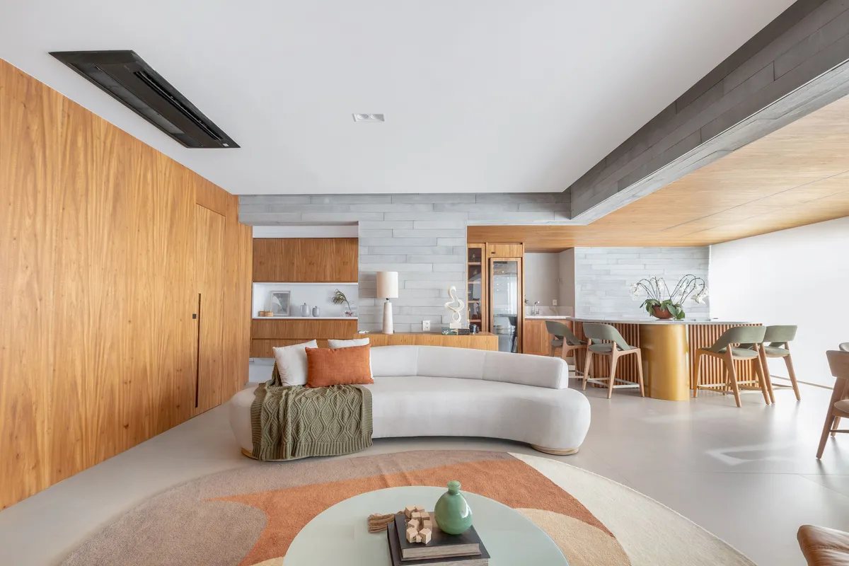 Fotografia de arquitetura e interiores: sala moderna com painel de madeira, sofá curvo, área de bar e design contemporâneo por Pâmela Wille